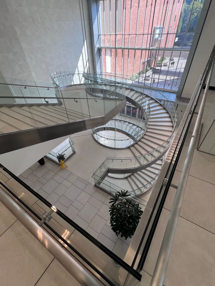 Elegant spiral staircase in a modern Portland, OR building with large windows.